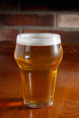 glass of light beer on wooden table