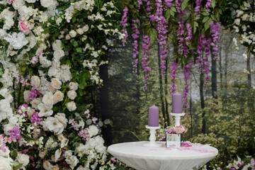 Fototapeta na wymiar Wedding ceremony Photo booth zone decorated with roses and candle composition.