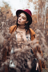 Fashionable woman in warm autumn clothes walks in the woods
