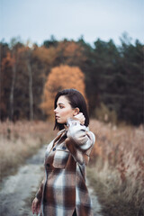 Outdoor fashion photo of young beautiful lady in autumn landscape with dry flowers. Knitted sweater, wine lipstick. Warm Autumn. Warm Spring