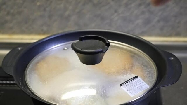 グツグツ煮立った鍋の蓋を開けるスローモーション動画
