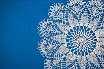 Closeup white lace napkin on blue background