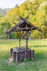 Old wooden well made of dry logs in the countryside 