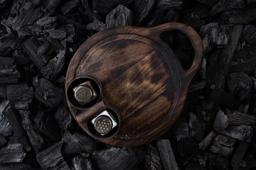 Cutting board for serving dishes. Salt and pepper on the board.