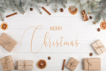 Gifts, fir tree and spices on a white table, top view, copy space, flat lay. Merry christmas inscription.