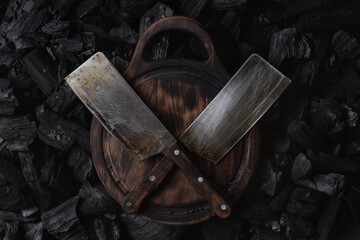 Two hatchets for meat on an old wooden board.