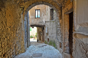 A small road crosses the old buildings of Prossedi, a medieval village in the Lazio region, Italy.