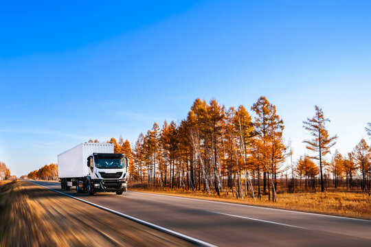 White semi-truck on autumn road