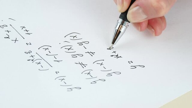 Calculation of mathematical formulas. A close-up hand writes an algebraic formula on a white sheet of paper. Distance learning.