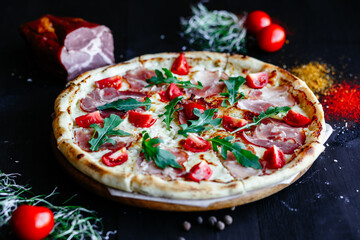 Thin pizza with ham and tomatoes