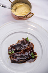 Beefsteak specialty prepared in olive oil with mashed potatoes