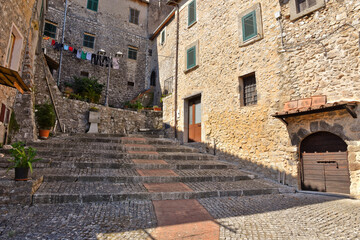 Fototapeta premium A small road crosses the old buildings of Prossed, a medieval village in the Lazio region, Italy.