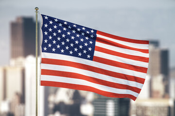 US flag on blurry skyscrapers background
