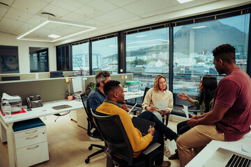 Fototapeta premium Mixed race business team testing each other before important board exam sitting in office