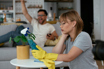  Sad woman cleaning home. Young tired woman at home.