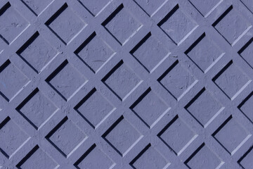 The surface of a concrete fence with a diamond-shaped relief.
