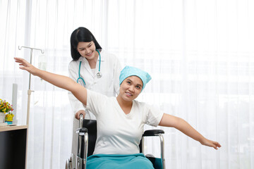 Obraz premium Asian female doctor provided treatment for patients sitting in a wheelchair, taking care closely. Cancer treatment hospital concept, health insurance.copy space