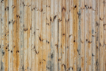 Fototapeta na wymiar Old vertical unpainted boards in a row. Great for backgrounds