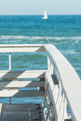 Obraz premium Close-up fragment of the old pier on the background of the sea and the yacht in defocus
