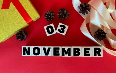 November 3.November 3 on wooden cubes on a red background.Autumn .Calendar for November.