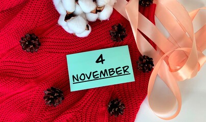 November 4.November 4 on a blue piece of paper.Cones, cotton and ribbon.Autumn .Calendar for November.