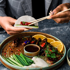 Obraz premium a woman eats a Peking duck