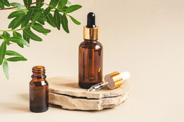 Two brown bottles of cosmetics on a natural beige background. Stone podium. Front view.