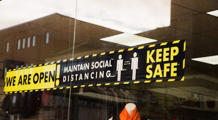 22/10/2020 Blackpool, England We Are Open! Maintain Social Distancing Keep Safe during COVID-19 sign on a shop window during corona virus advising people to come inside