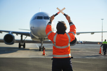 The runway traffic controller uses gestures and sticks to help the aircraft choose the correct trajectory around the airfield