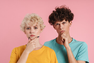 Portrait of a pensive teenage couple standing isolated