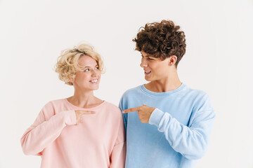 Happy loving couple pointing to each other