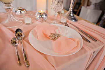 Wedding table setting with tablecloths, expensive dishes and decorations.