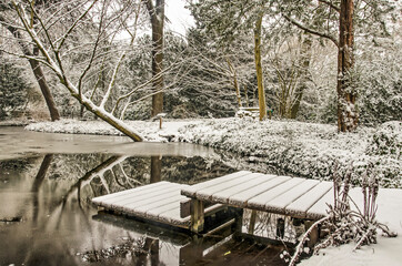 Rotterdam, The Netherlands, January 22, 2020: small jetty in a pond in Schoonoord park on a winter day after fresh snowfall