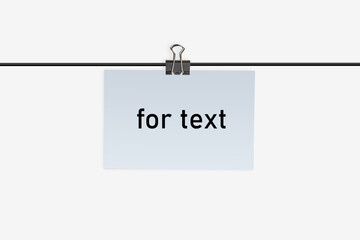 A small piece of paper with inscription for text, clamped by binder clip to a wire and hanging on it. Isolated on white. Close up, copy space