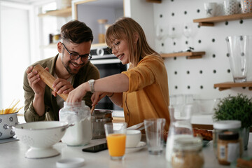 Husband and wife in kitchen. Young couple preparing delicious food at home.
