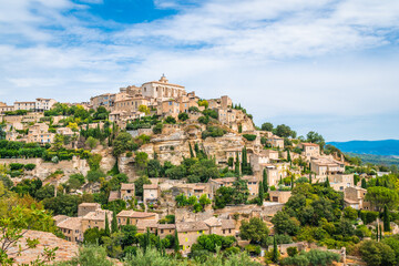 Fototapeta na wymiar Old Provencal village on the cliff with houses of stone and plenty of greenery - Gordes, Provence, France