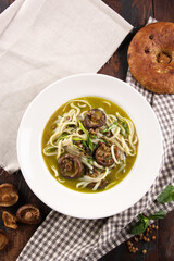 East Asian cuisine. Shiitake mushroom soup with lentils, noodles and fresh herbs in a white plate. Pita on an old wooden table. Rustic. Background image, copy space. Flatlay, top view