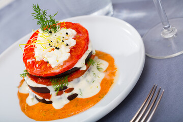 Roasted grill slices of eggplant and tomato dressed with spicy sauce served on plate