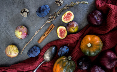 Fresh fruits and vegetables on a table: plums, grapes, pumpkin and figs.  Autumn mood still life. 