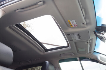 View of the ceiling of the car with a transparent glass hatch for airing, opening in summer while...