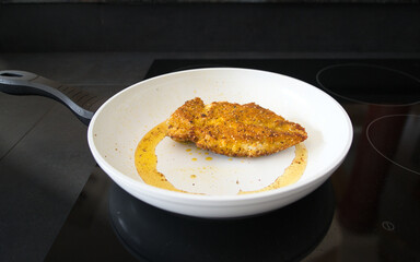 Hähnchenbrust, Schnitzel mit Flohsamenschalen und Chili Panade beim Anbraten