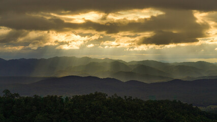 Golden Sun ray through cloudy sky with long mountain range in Tak, Thailand