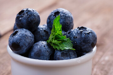 Blueberries with mint leaf in water drops close-up