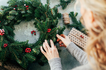 Woman makes a fir wreath for advent. Christmas Eve and crafting decorating. New Year celebration.
