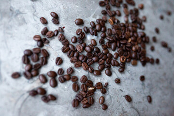 Top view of dark coffee beans decoratively placed on a marble plate
