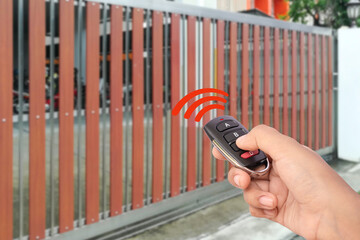 	
Woman in car, hand opening the automatic gate by using remote control.