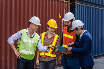 Group of staff worker standing and checking the containers box from cargo ship for export and import