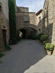Fototapeta na wymiar medieval village. Stone walls with an arch in the background. Monells