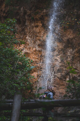 Joven senderista observando la caída del agua. 
Young hiker observing the falling water.
