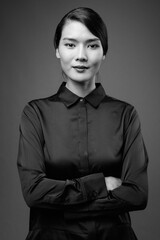 Studio shot of beautiful Asian businesswoman against gray background © Ranta Images